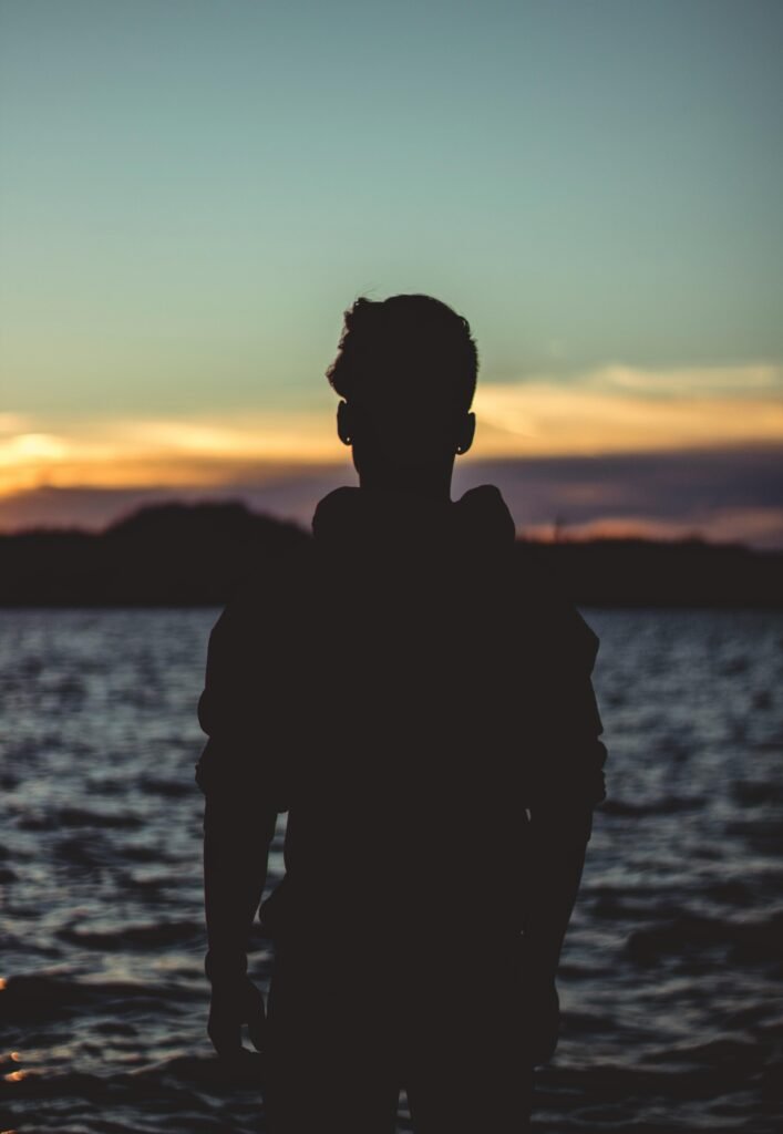 Silhouette Photo of Person Near Body of Water